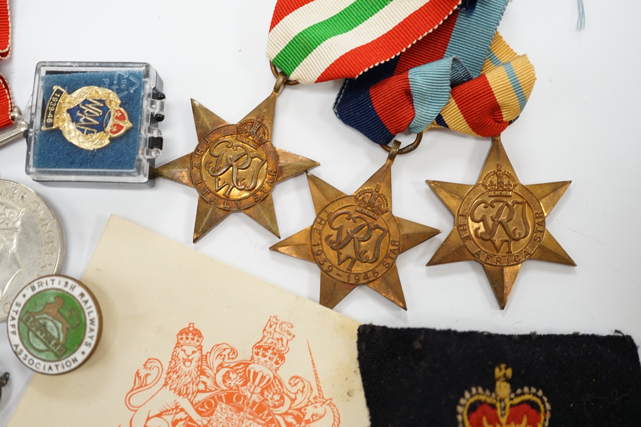 A WWII medal group, comprising of the 1939-1945 War Medal, the Defence Medal, the Africa Star, the Italy Star and the 1939-1945 Star, together with a Royal Artillery sweetheart badge, a cap badge and various other items.